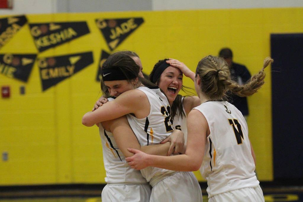 Three girls from the basketball team celebrating a victory